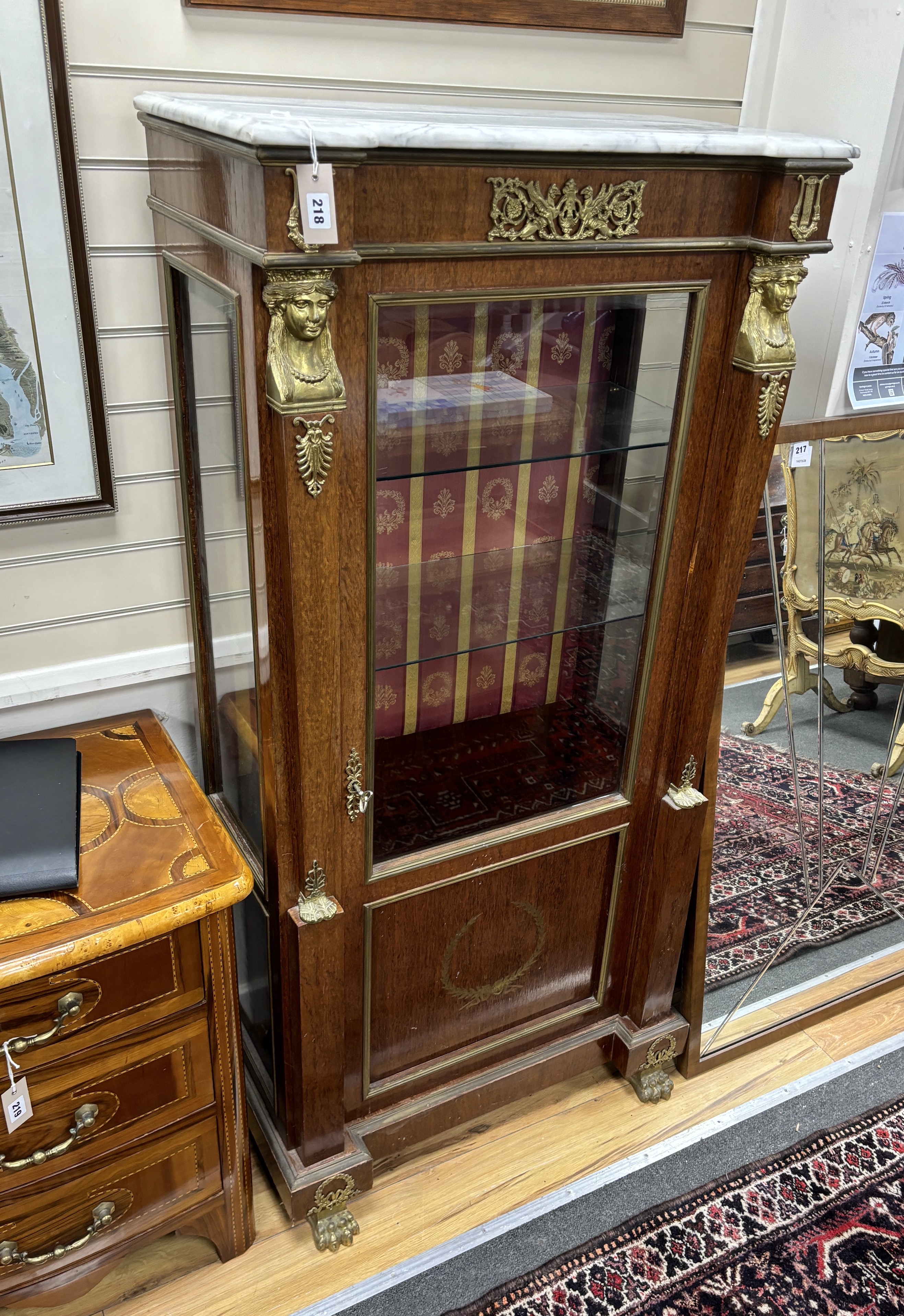 A French Empire style gilt metal mounted marble topped mahogany vitrine, width 78cm, depth 42cm, height 163cm